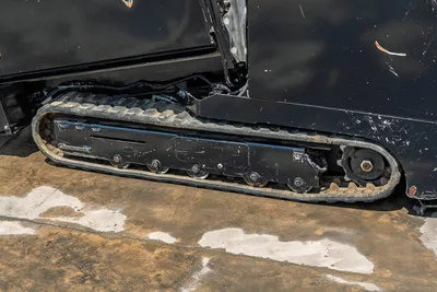 2021 Vermeer D8x12 rubber track close-up, drive sprocket, roller wheels, hydraulic lines visible, wear consistent with use