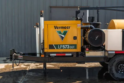 2024 Vermeer LP573SGT vacuum excavator side view, showing engine enclosure, trailer frame, tank components, and tires.