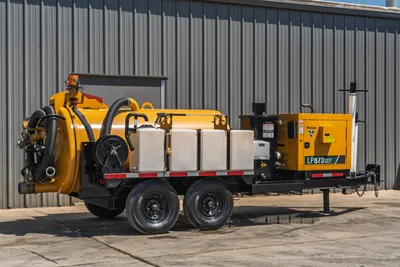 Vermeer LP873SDT trailer-mounted vacuum excavator, passenger side view, yellow debris tank, water tanks, vacuum hose, spoil door, diesel power unit