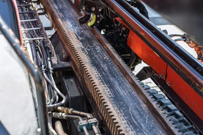 2018 Ditch Witch JT30 All Terrain drill frame rack-and-pinion carriage rail, hydraulic lines, close-up detail view