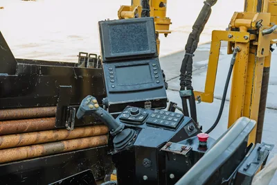 2021 Vermeer D23x30 S3 operator console with dual displays, joystick controls, keypad, red E-stop, and loaded drill pipe rack visible