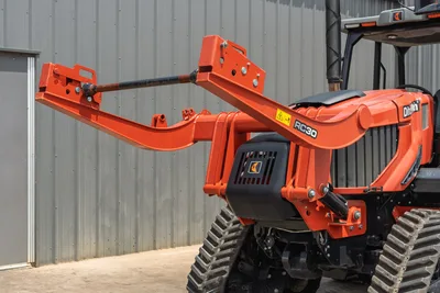 2024 Ditch Witch RT125Q RC30 pipe loader arm close-up, orange frame, rubber tracks, hydraulic cylinder, Ditch Witch badging visible
