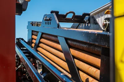 Ditch Witch JT30 All Terrain drill pipe rack and threaded pipe segments loaded in the magazine, close-up side view.