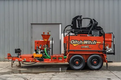 2015 Ditch Witch MR90 mud recycler, side view, tandem-axle trailer, mixing hopper, green suction hoses, hydraulic lines, control panel visible