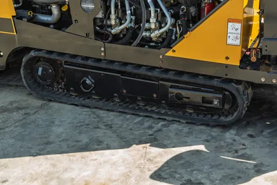 2022 Vermeer D23x30 S3 rubber track undercarriage, close-up side view showing hydraulic lines and open engine compartment