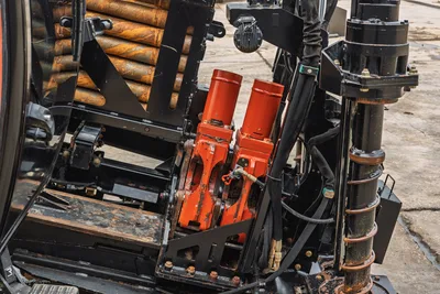 2021 Ditch Witch AT40 drill pipe rack, pipe loader mechanism, and gearbox assembly in a close-up, side-angle view.