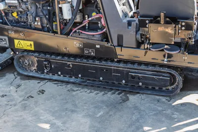 2020 Ditch Witch JT10 tracked HDD machine side view showing engine compartment, hydraulic lines, and rubber track undercarriage