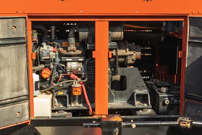 2022 Ditch Witch HX30 mud mixer open engine compartment showing alternator, starter, battery, fuel filter, and pump drive components