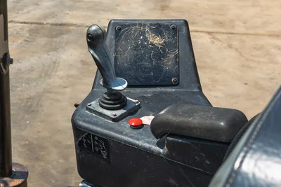 2021 Ditch Witch JT20 operator console closeup showing joystick control, red E-stop button, armrest, wear-marked surfaces