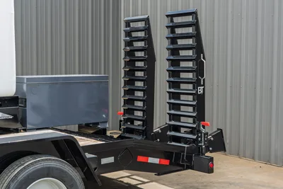 2026 Behnke CBCT2324E-BT-R trailer rear view showing dual fold-down loading ramps with red locking pins and BT branding