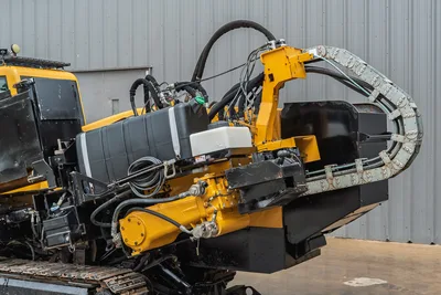 Side view of 2017 Vermeer 40x55 S3 drill, showcasing hydraulic hoses, cable track, fuel tank, and carriage assembly.