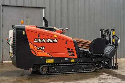 2016 Ditch Witch JT9 HDD drill, 3/4 rear view, rubber tracks, loaded drill pipe rack, operator controls, orange bodywork, good condition
