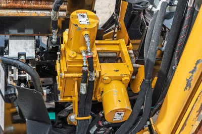 2024 Vermeer D20x22 S3 hydraulic drive motor and gearbox close-up, yellow housing, hydraulic hoses, warning decals visible
