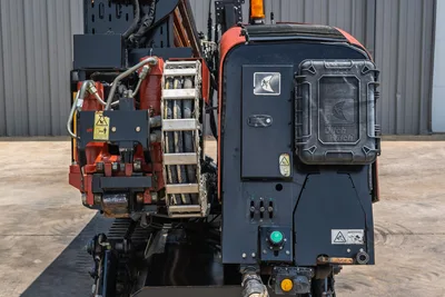 2017 Ditch Witch JT20 rear view showing pipe rack, hydraulic lines, engine enclosure with branded panels, tracks, and amber warning light