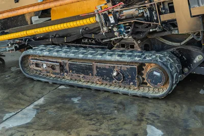 2021 Vermeer D23x30 S3 rubber track undercarriage, close-up side view, drive sprocket, hydraulic lines visible above