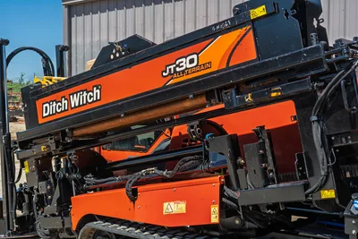 2016 Ditch Witch JT30 All Terrain drill rig, side profile showing fluid drill pipe, orange frame, and black track system.
