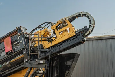 2017 Vermeer D100x140 S3 drill frame angled upward, yellow carriage with hydraulic hoses, cable carrier chain visible overhead