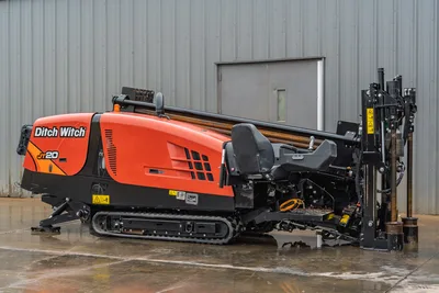 Ditch Witch JT20 HDD rig with tracked undercarriage, orange cab, drill head, and 10-foot drill pipe assembly visible