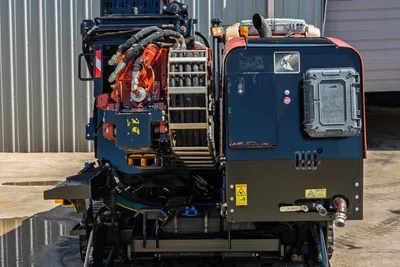 Rear view of Ditch Witch JT30 All Terrain drill rig showing engine housing, hydraulic hoses, and carriage assembly.