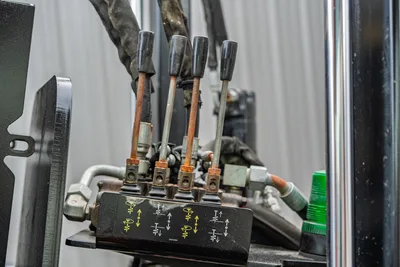 Ditch Witch JT3020 operator control levers and hydraulic assembly close-up, showing labeled console and hydraulic components.