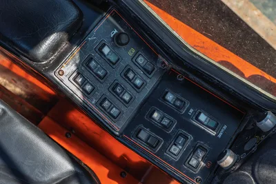 2014 Ditch Witch JT100 Mach 1 operator console, worn switch panel with rocker controls, SET/RESUME buttons, orange trim, used condition