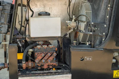 2021 Ditch Witch JT28 open engine compartment showing hydraulic reservoir, cooling fan, hydraulic pump block, and hose routing