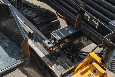 2021 Vermeer D24x40 S3 drill frame closeup showing rack-and-pinion carriage, rubber tracks, drill pipe stack, and hydraulic fittings