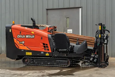 2016 Ditch Witch JT9 HDD drill, side profile, orange hood, rubber tracks, loaded drill pipe rack, carriage assembly visible