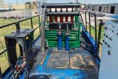 American Augers M300DH mud recycler top view; red hydrocyclone cones, green shaker deck, blue manifold pipes, black frame, AC control panel
