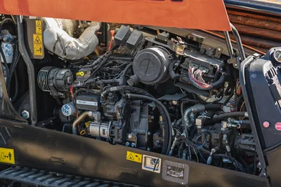 Open engine compartment of 2023 Ditch Witch JT20, highlighting 74 hp engine, hydraulic components, and wiring harness.