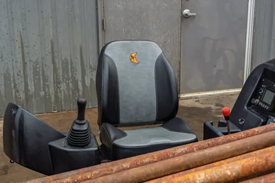 2016 Ditch Witch JT9 operator seat with joystick controls, digital display panel, and loaded drill pipe rack visible foreground