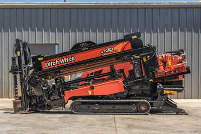 2018 Ditch Witch JT30 All Terrain HDD drill, side profile, drill frame elevated, loaded drill pipe, rubber tracks, vise assembly visible