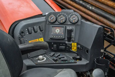 Ditch Witch JT20 operator cab control panel with analog gauges, digital display, joystick controls, and warning labels