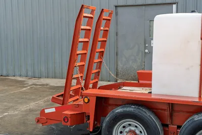 2019 Belshe WB14-2EP mud trailer rear view, orange fold-up ramps chained upright, white poly tank, tandem axle