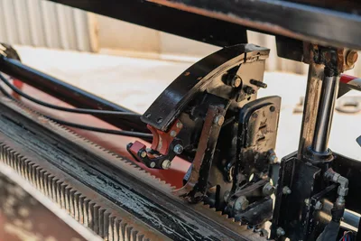 2022 Ditch Witch JT20 drill frame close-up showing rack-and-pinion thrust system, carriage assembly, hydraulic cylinder, and pipe vise