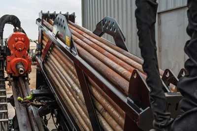 2016 Ditch Witch JT25 drill pipe rack loaded with used 2.375" HDD drill stems, red spindle drive visible left