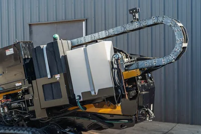 2016 Vermeer D23x30 S3 HDD drill rear view showing fluid tank, cable carrier drag chain, hydraulic lines, and rubber tracks