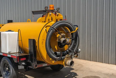 Vermeer LP873SDT vacuum excavator rear tank view showing coiled suction hose, cam-lock fittings, amber beacon, and white water tank