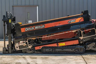 Side profile of 2018 Ditch Witch JT20 HDD drill, showing tracks, pipe loader, drilling rack, and engine cowling.