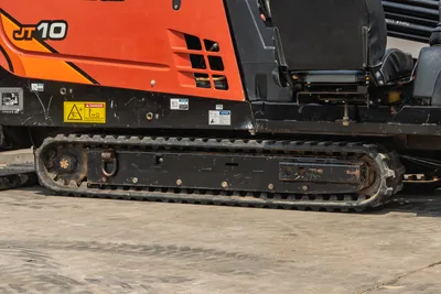 2018 Ditch Witch JT10 side profile, showing rubber tracks, operator seat, engine housing, and drill rod rack in good condition.