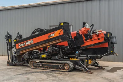2021 Ditch Witch JT25 horizontal directional drill, side view, showing tracks, pipe rack, and rotation manifold assembly.