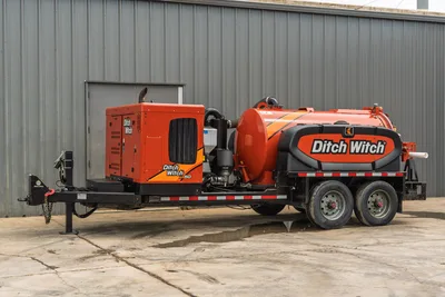2023 Ditch Witch HX50 mud recycler on tandem-axle trailer, full driver-side view, orange vacuum tank, engine enclosure, hose connections visible