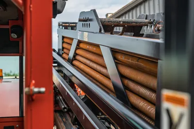 Side view of Ditch Witch JT3020 pipe rack showing stored 2.375-inch drill pipe sections with weathered finish.