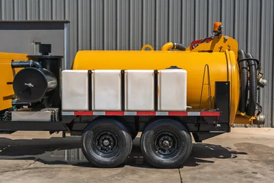 Vermeer LP873SDT vacuum excavator trailer, side view showing yellow debris tank, white water tanks, dual axle, suction hoses, and separator unit.