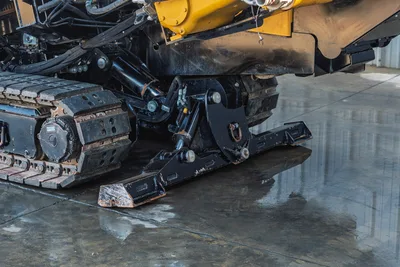 Vermeer 40x55DR S3 undercarriage detail showing tracked base, hydraulic systems, and yellow rotary head assembly from low angle