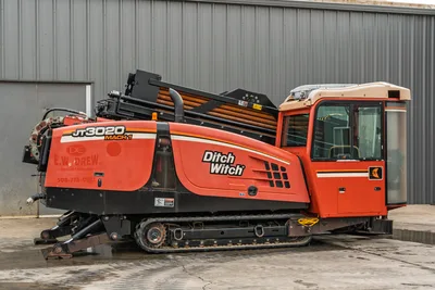 2012 Ditch Witch JT3020 Mach 1 HDD drill, profile view, showing tracks, enclosed cab, engine compartment, and drill pipe rack.
