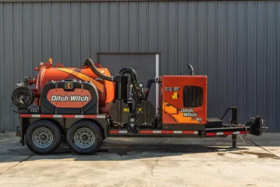 2022 Ditch Witch HX30 hydrovac trailer, full driver-side view, orange 500-gal debris tank, vacuum hose, engine enclosure, tandem axle