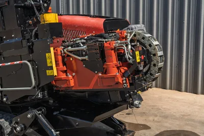 2022 Ditch Witch JT20 drill carriage close-up showing rotary drive, hydraulic lines, chain drive, and safety labels