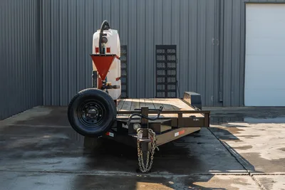 2023 MAXX-D C6X mud mixing trailer, front view, wood deck, white poly tank, red hopper funnel, spare tire, safety chains