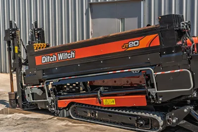 2022 Ditch Witch JT20 HDD drill, side angle showing drill frame, rubber tracks, hydraulic components, and drill pipe loaded on carriage.